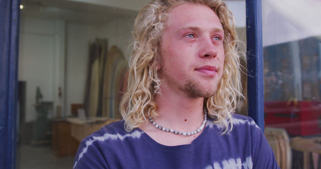 Young Man with Blond Curly Hair Looking Away Thoughtfully - Free Images, Stock Photos and Pictures on Pikwizard.com