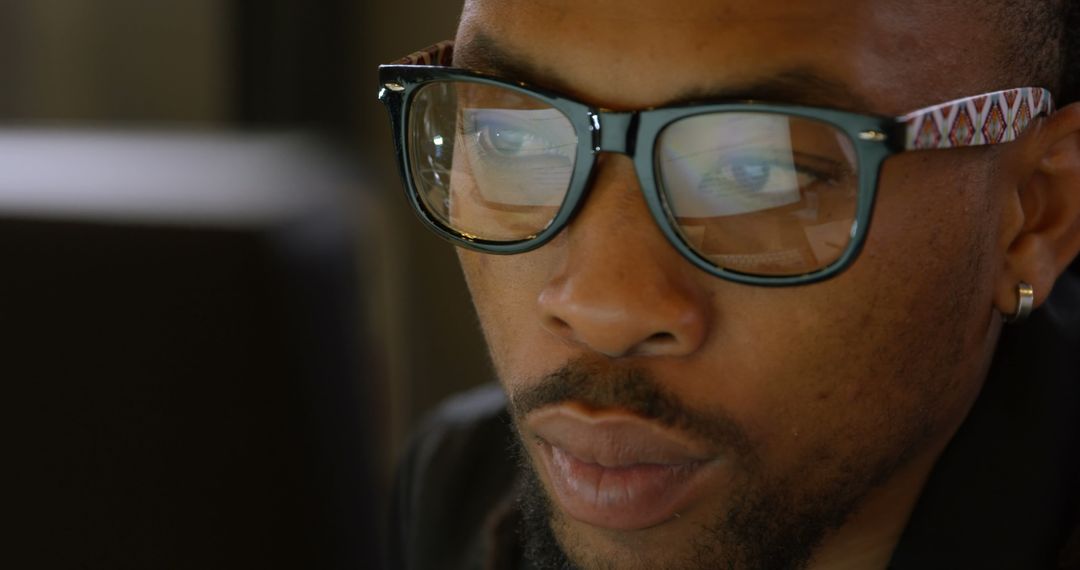 Focused Male Executive Working on Computer with Glasses Reflecting Screen