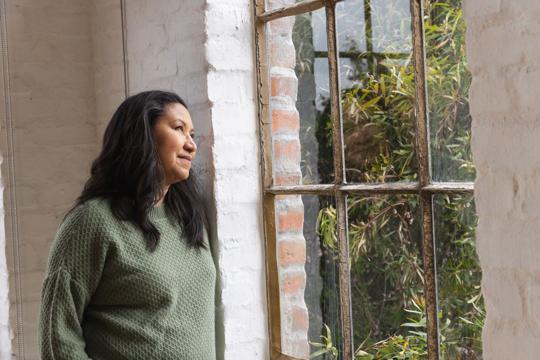 Woman Reflecting By Rustic Window with Garden View