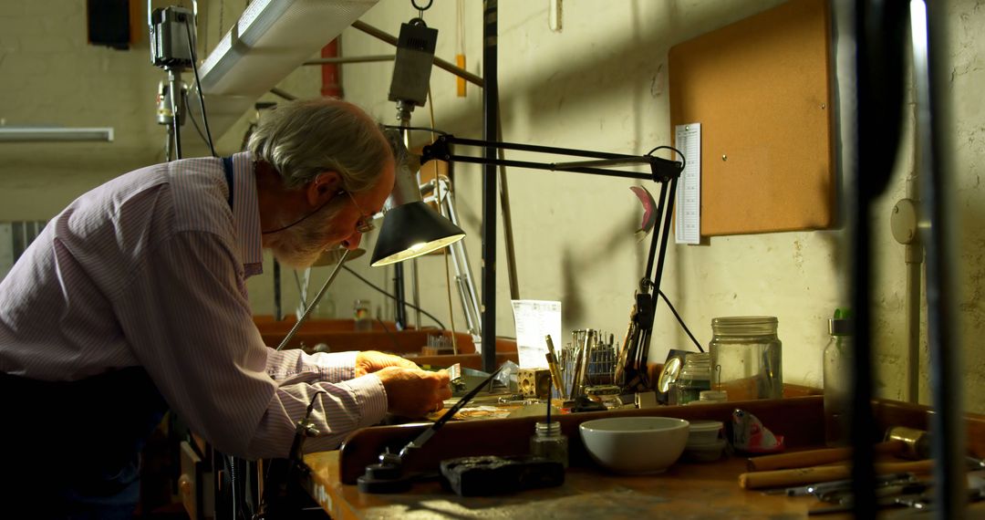 Senior Craftsman Working in Workshop Under Task Light - Free Images, Stock Photos and Pictures on Pikwizard.com