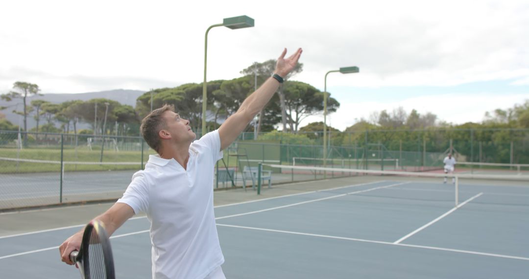 Man Serving Tennis Ball Outdoors on Court - Free Images, Stock Photos and Pictures on Pikwizard.com