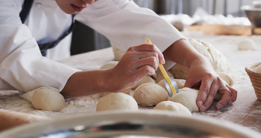 Asian Female Baker Slashing Dough in Bakery Kitchen