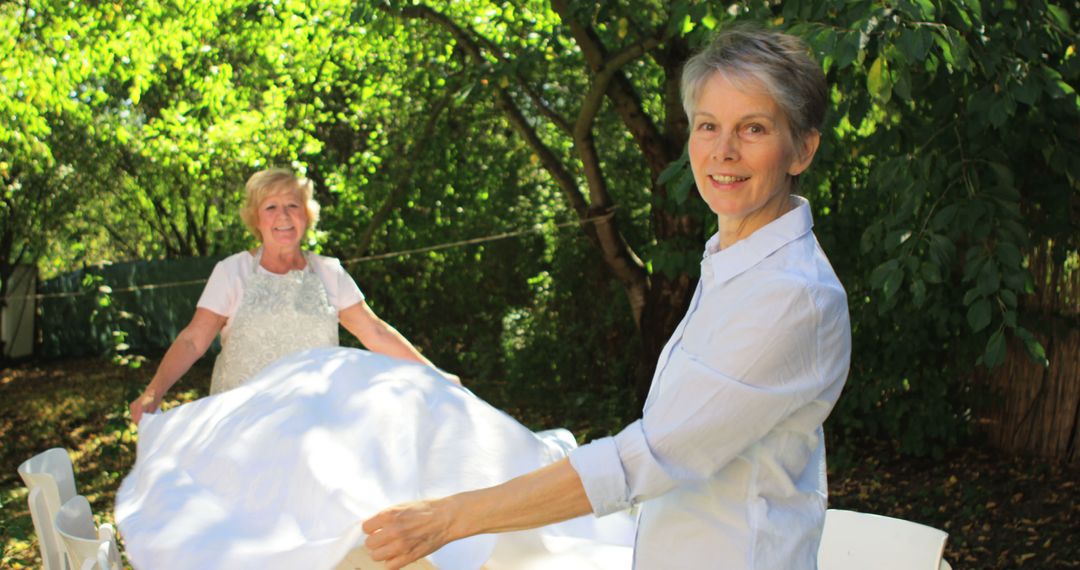 Two Senior Women Setting a Table Outdoors in a Garden - Free Images, Stock Photos and Pictures on Pikwizard.com