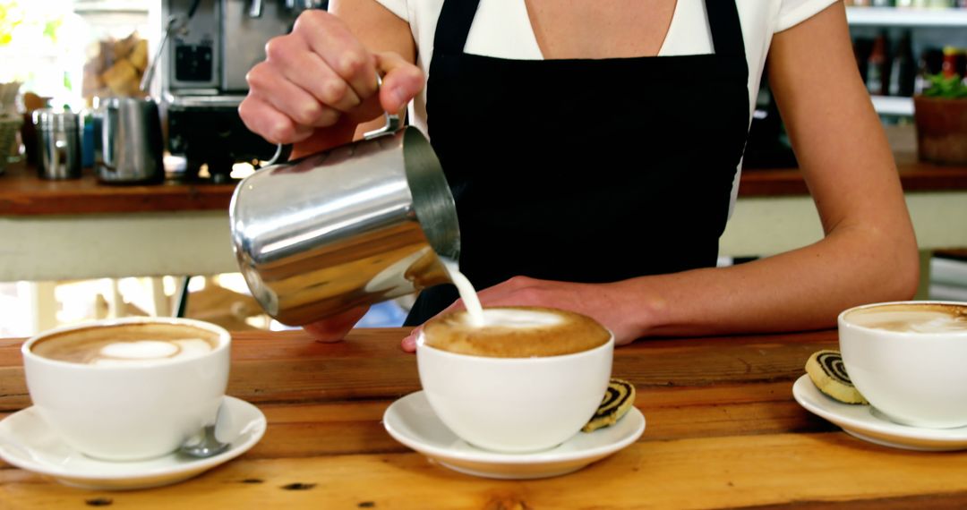 Barista Pouring Milk into Cappuccinos at Rustic Coffee Shop - Free Images, Stock Photos and Pictures on Pikwizard.com