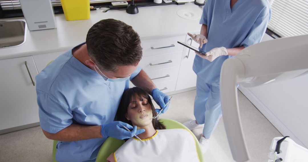 Dentist Treats Patient While Assistant Takes Notes in Modern Clinic - Free Images, Stock Photos and Pictures on Pikwizard.com