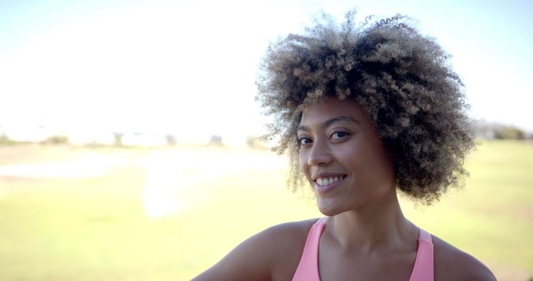 Smiling Woman with Curly Hair Enjoying Outdoor Activities