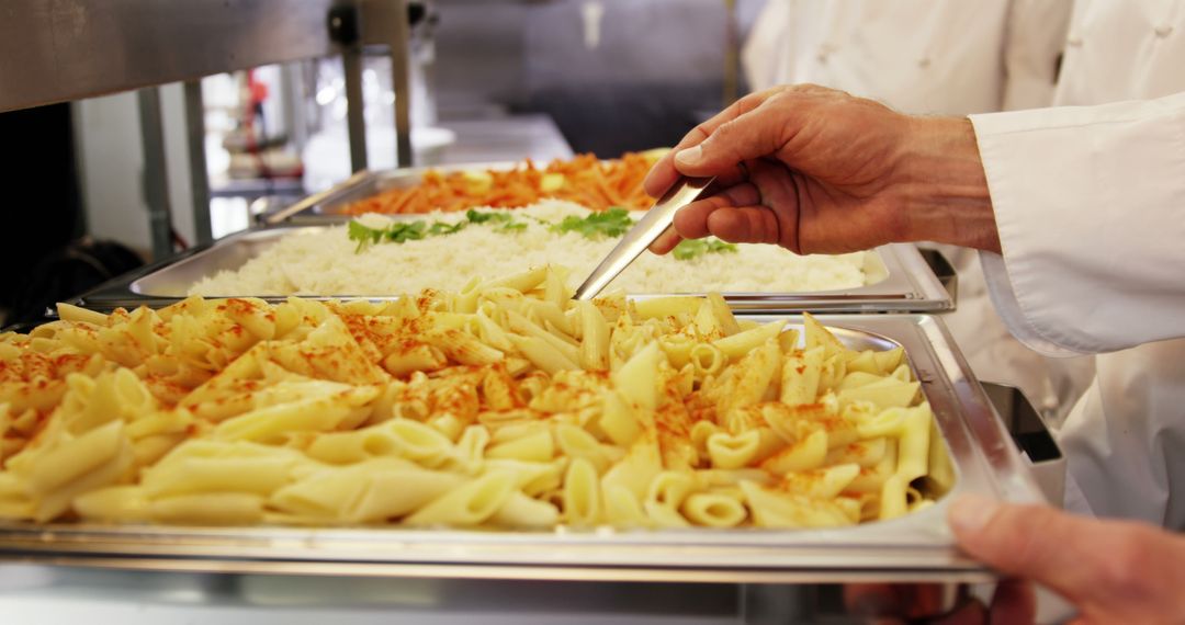 Chef Preparing Pasta and Rice Trays in a Restaurant Kitchen - Free Images, Stock Photos and Pictures on Pikwizard.com