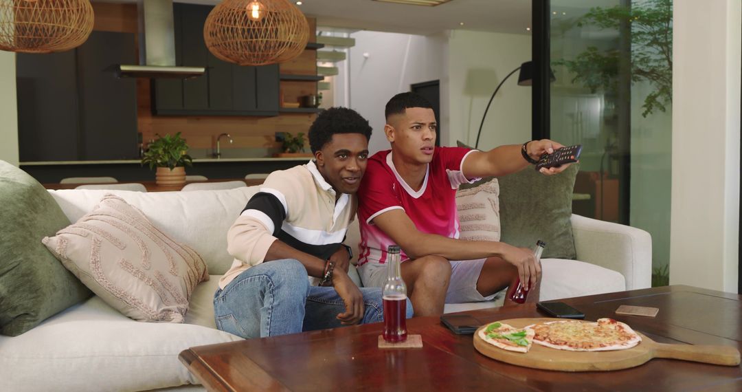 Diverse Friends Relaxing at Home Watching TV and Enjoying Pizza