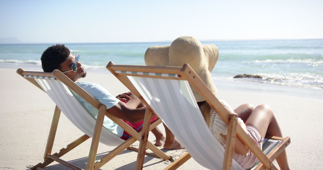 Couple Relaxing on Beach Chairs by Tranquil Sea