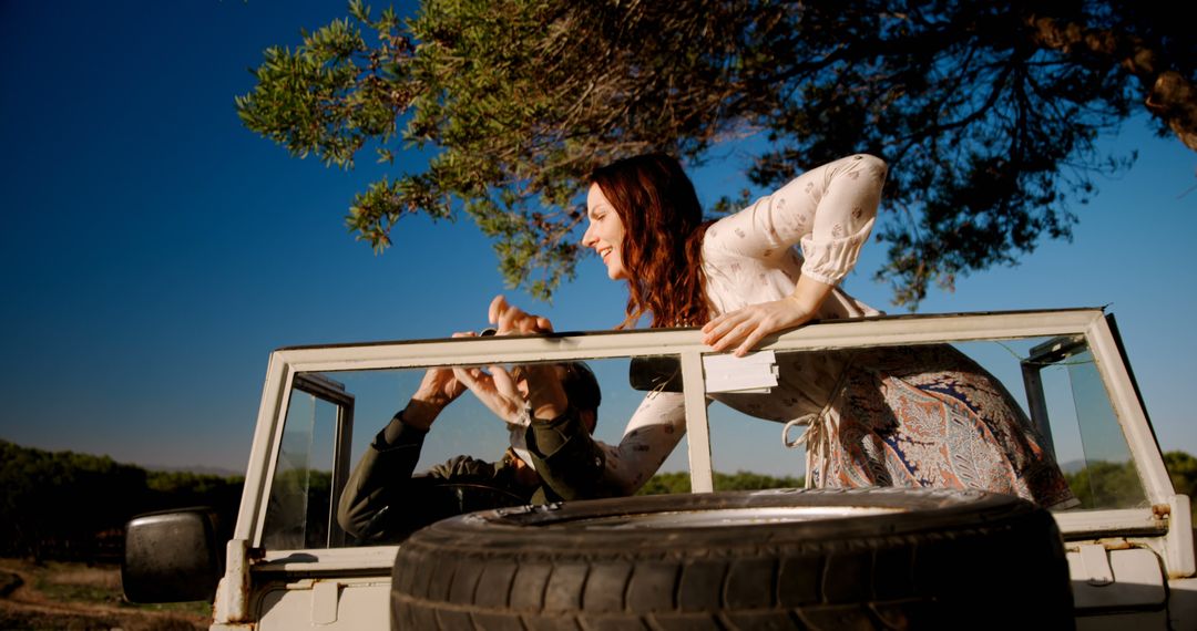 Cheerful Woman Enjoying Road Trip on Sunny Day with Vintage Car