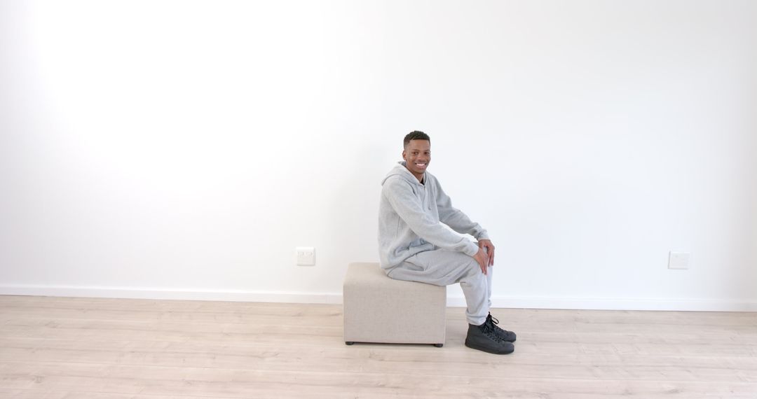 Man Relaxing in Modern Minimalist Room Wearing Casual Tracksuit
