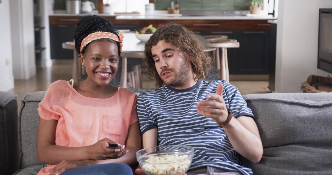 Diverse Couple Enjoying Movie Night at Home with Popcorn