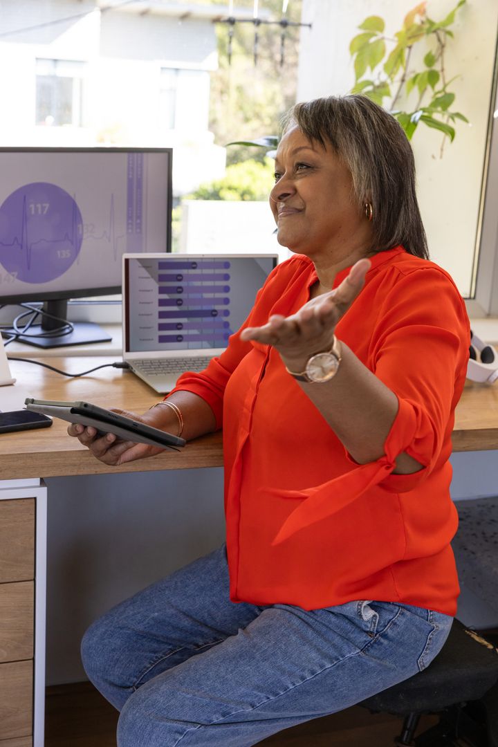 Senior Woman Analyzing Data on Tablet in Vibrant Work-from-Home Environment
