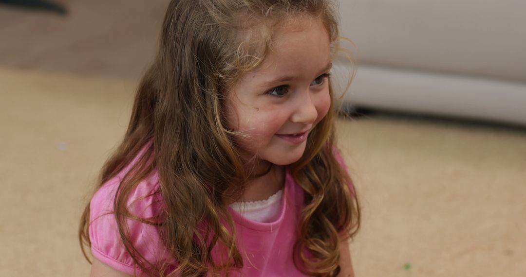 Smiling Little Girl Sitting on Floor at Home - Free Images, Stock Photos and Pictures on Pikwizard.com