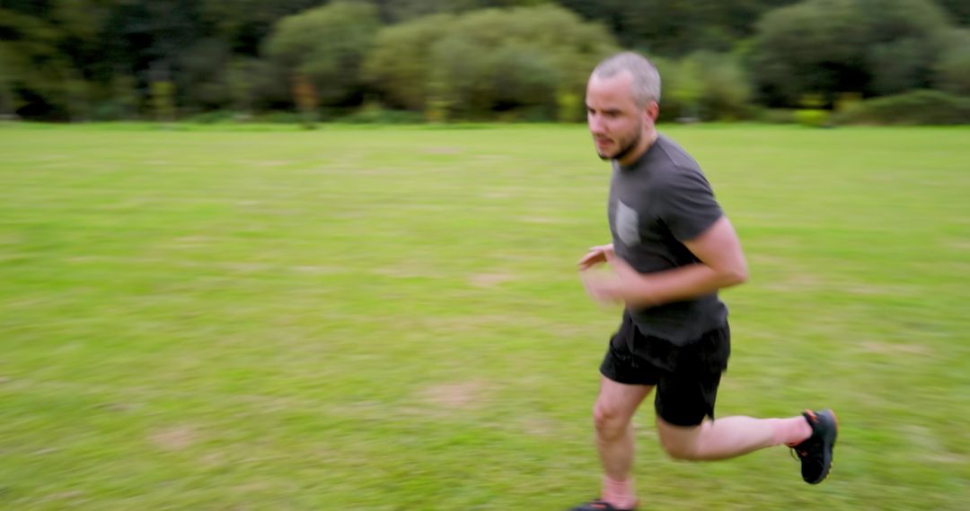 Man Jogging Energetically on Lush Green Field in Nature