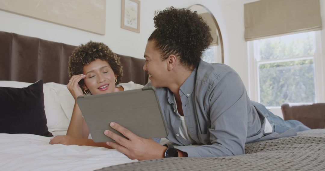 African American Couple Using Tablet Together in Cozy Bedroom