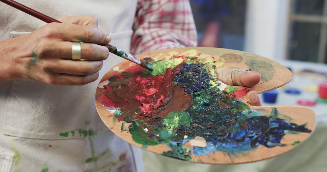 Artist Mixing Colors on Palette with Paintbrush in Studio - Free Images, Stock Photos and Pictures on Pikwizard.com