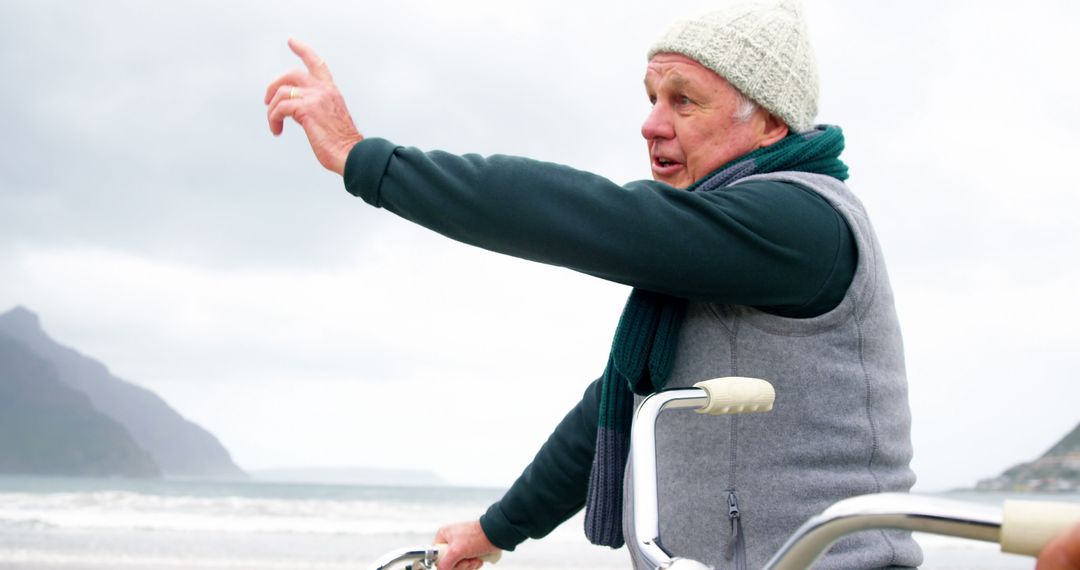 Senior Man Pointing Direction While Cycling on Beach - Free Images, Stock Photos and Pictures on Pikwizard.com