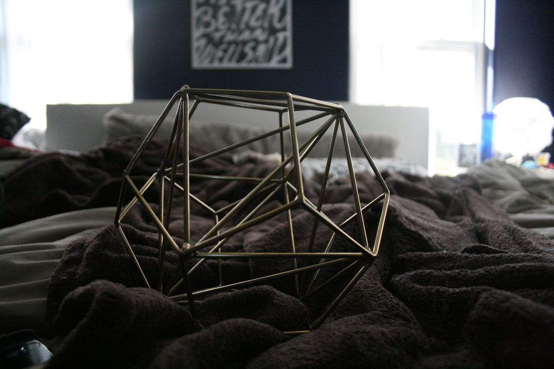 Geometric Metal Sculpture on Cozy Bed with Throws - Free Images, Stock Photos and Pictures on Pikwizard.com