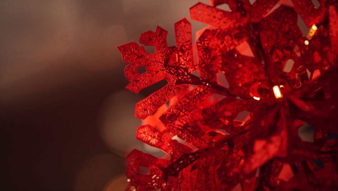 Sparkling Red Snowflake Ornament Closeup with Warm Bokeh Holiday Light Decorative Bauble