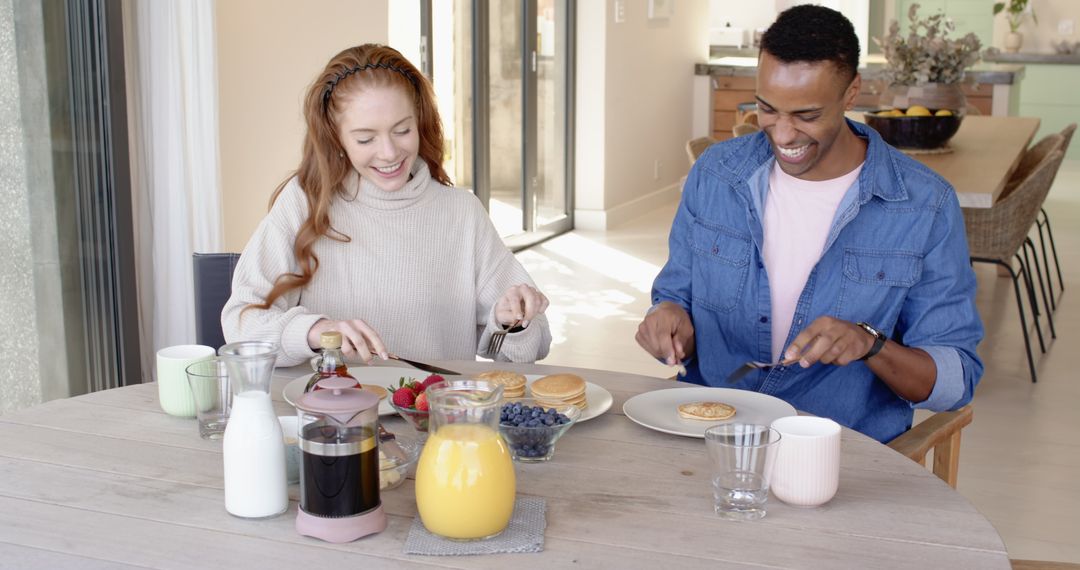 Happy Couple Enjoying Pancake Breakfast in Sunlit Home