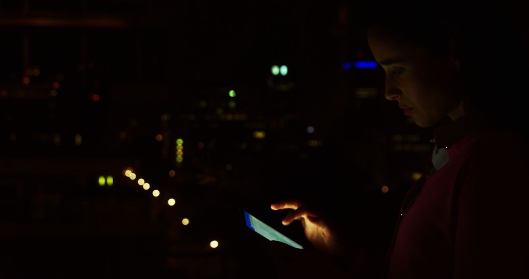 Woman Using Tablet in Dark Cityscape Environment - Free Images, Stock Photos and Pictures on Pikwizard.com