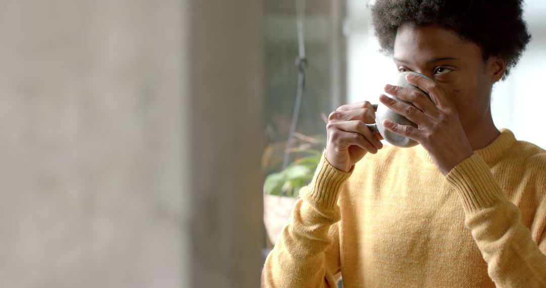 Young African American drinking coffee at home - Free Images, Stock Photos and Pictures on Pikwizard.com