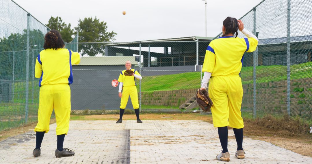 Female Softball Players Practicing Throwing and Catching