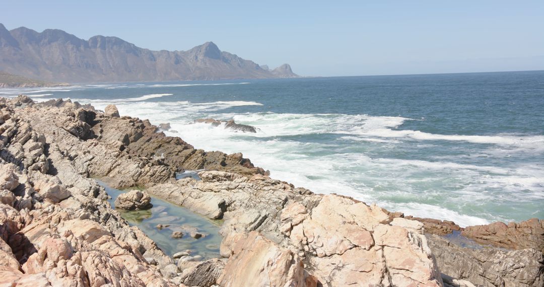 Scenic view of mountain coastline with rocky beach and sea on sunny day - Free Images, Stock Photos and Pictures on Pikwizard.com