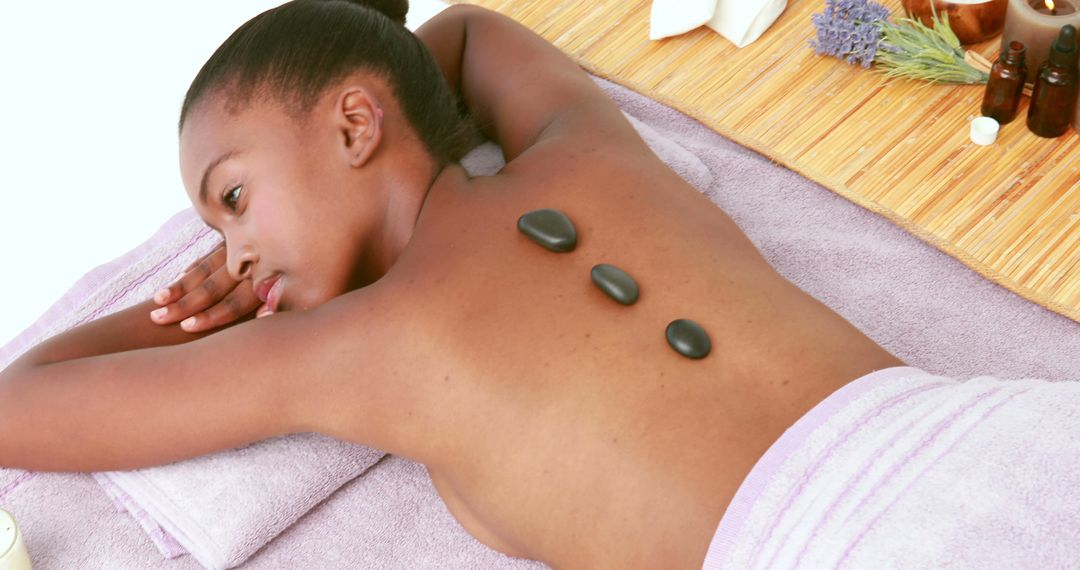 Woman Relaxing with Hot Stone Therapy in Spa Setting - Free Images, Stock Photos and Pictures on Pikwizard.com