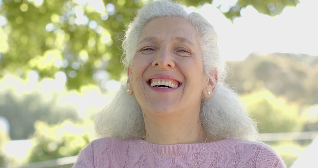 Happy Senior Woman Smiling Outdoors in Sunny Park - Free Images, Stock Photos and Pictures on Pikwizard.com