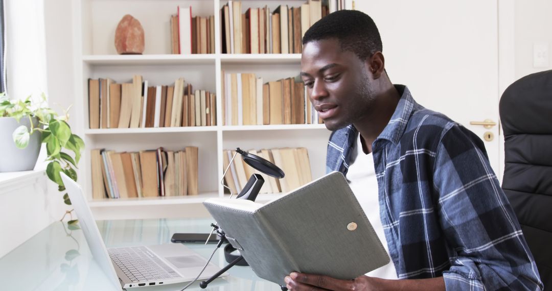 Focused Man Recording Podcast in Home Office with Laptop and Microphone