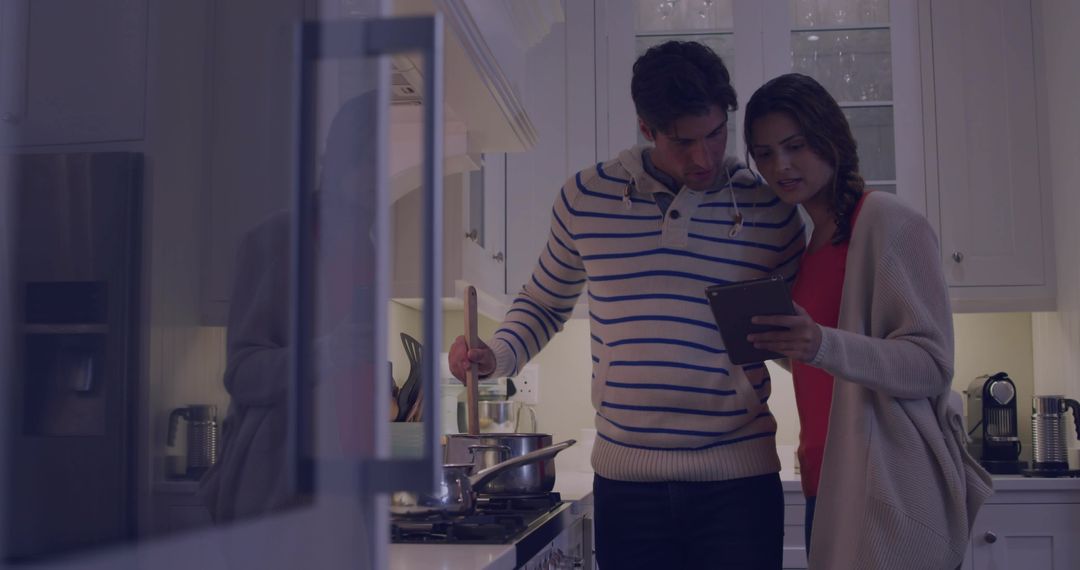 Couple Cooking Together in Kitchen While Using Tablet