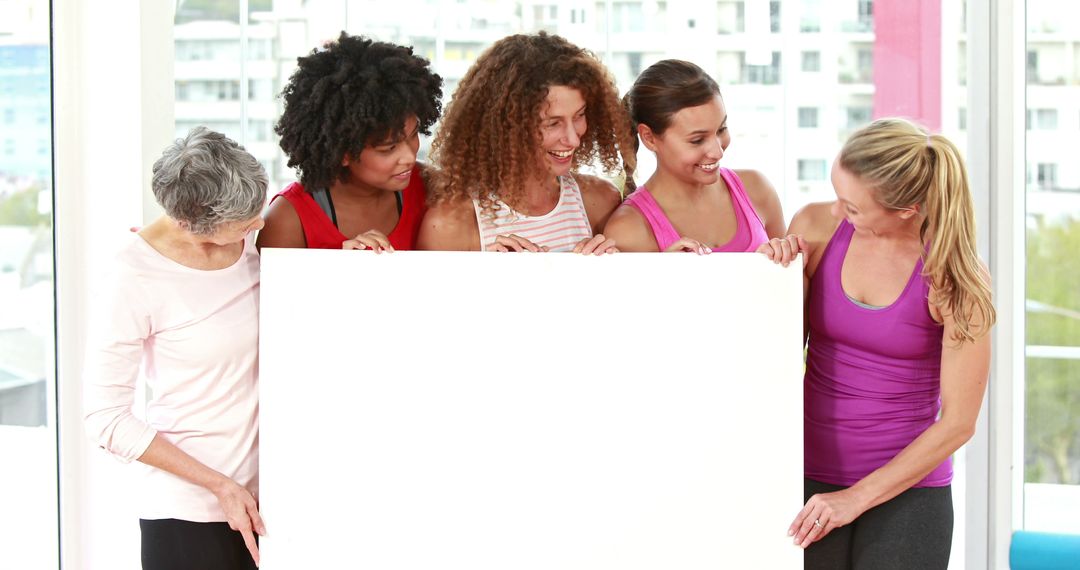 Diverse Group of Women Holding Blank Poster at Gym - Free Images, Stock Photos and Pictures on Pikwizard.com