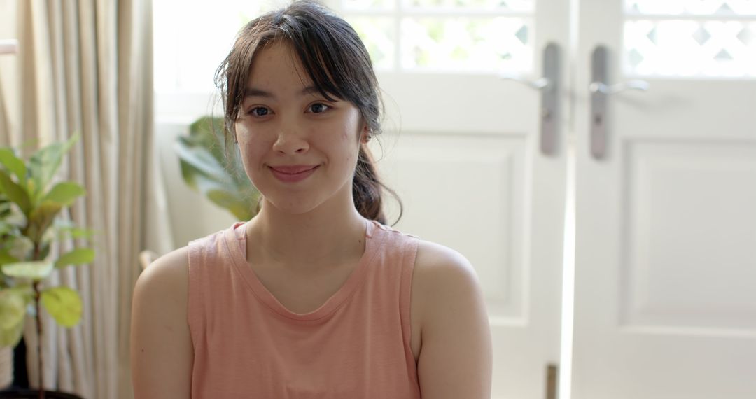 Smiling Asian Woman Relaxing in Cozy Minimalist Home Setting