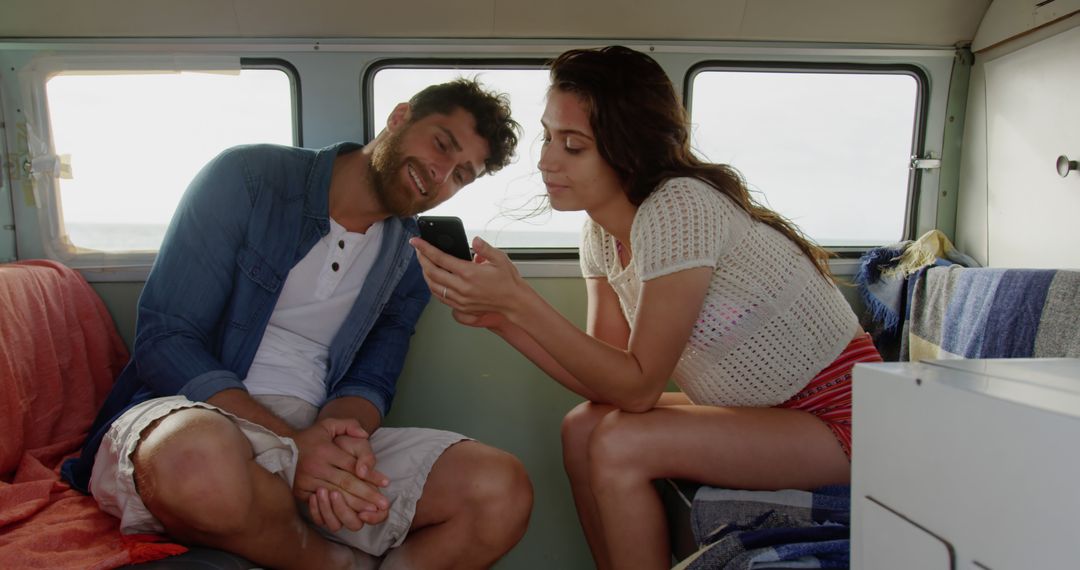 Young Couple Using Smartphone in Camper Van - Free Images, Stock Photos and Pictures on Pikwizard.com