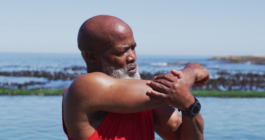 Senior African American Man Stretching Outdoors by the Ocean - Free Images, Stock Photos and Pictures on Pikwizard.com