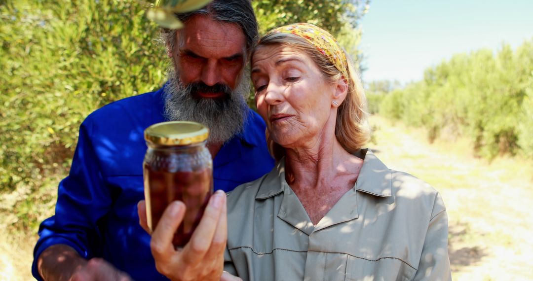 Senior Couple Holding Jar of Preserved Olives in Countryside - Free Images, Stock Photos and Pictures on Pikwizard.com