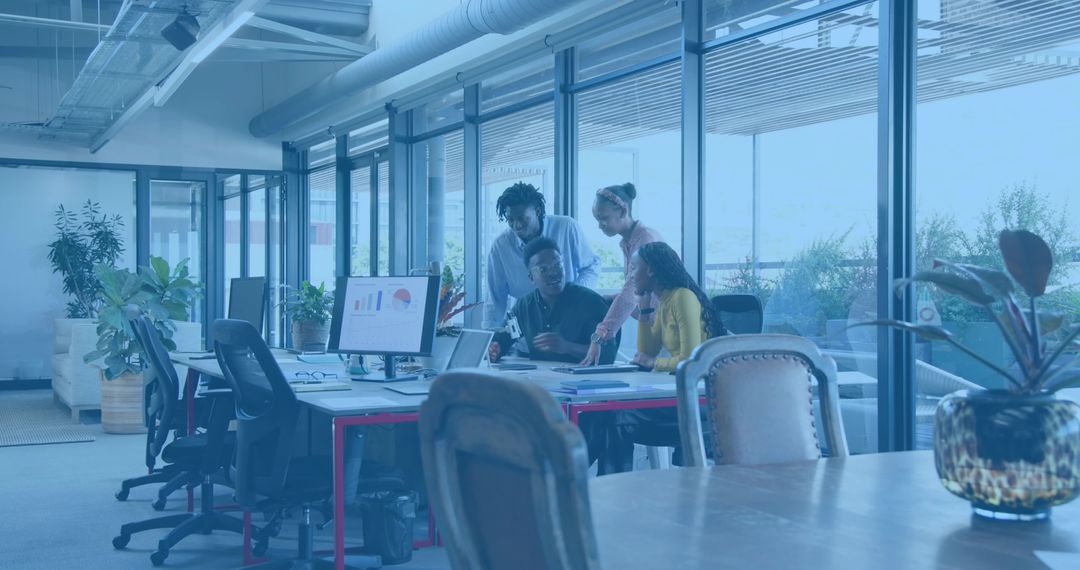 Diverse Team Collaborating Over Analytics Dashboard in Modern Open Office