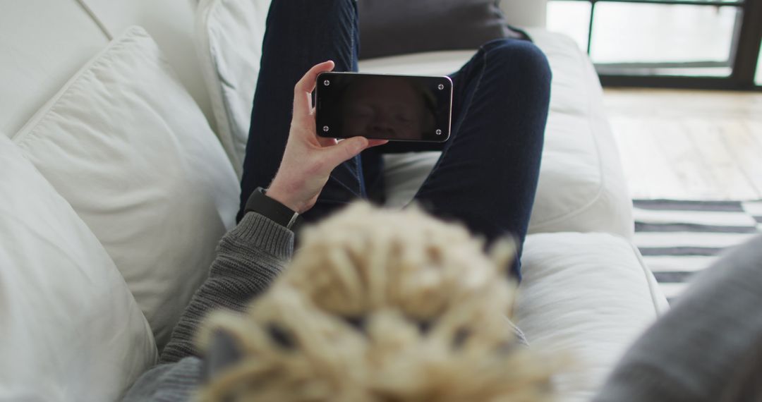 Person Relaxing on Sofa Watching Content on Smartphone - Free Images, Stock Photos and Pictures on Pikwizard.com