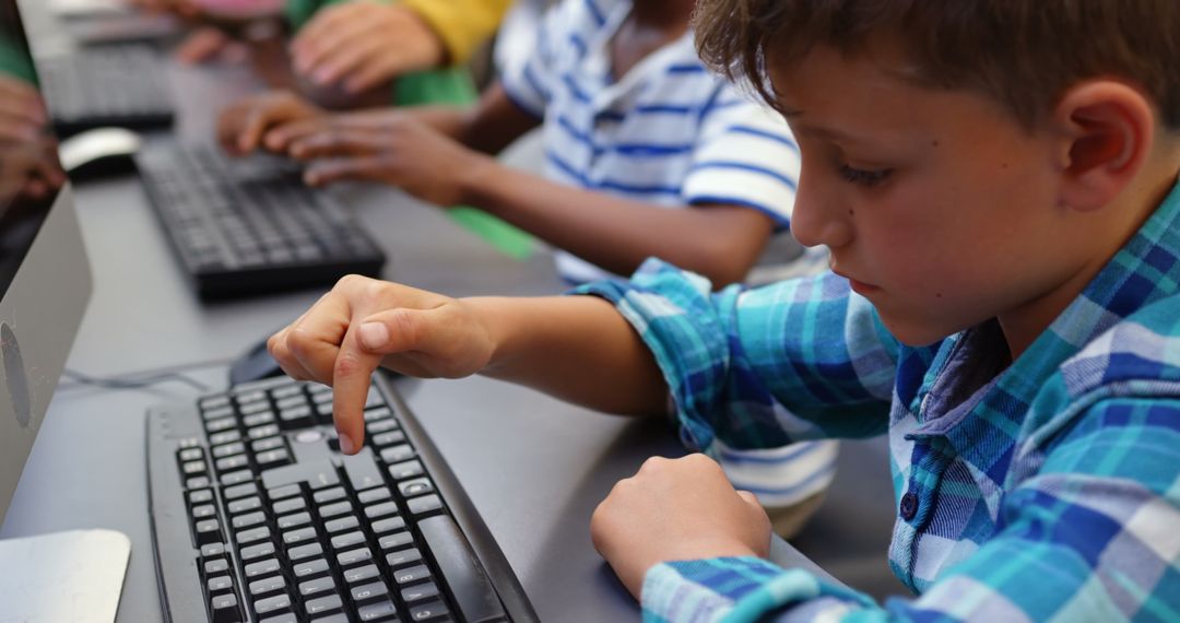 Young Students Focusing on Keyboard Skills in Classroom