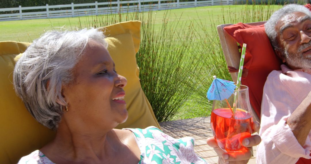 Senior Couple Relaxing with Cocktails in Sunny Backyard