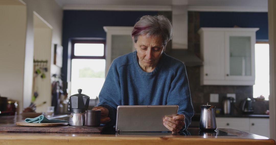 Senior Woman Using Tablet in Cozy Kitchen - Free Images, Stock Photos and Pictures on Pikwizard.com