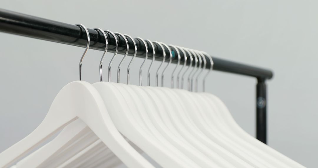 Row of Minimalist White Hangers on Black Rack - Free Images, Stock Photos and Pictures on Pikwizard.com