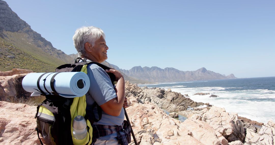 Senior Woman Hiking Along Scenic Coastal Trail with Backpack - Free Images, Stock Photos and Pictures on Pikwizard.com