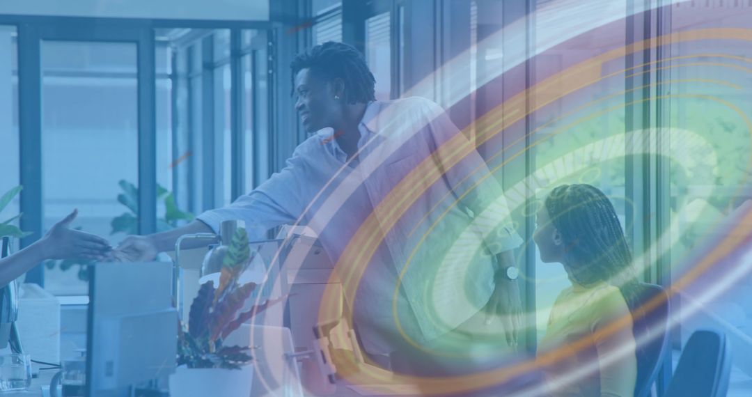 Shaking hands in modern open-plan office with digital swirl overlay promoting collaboration