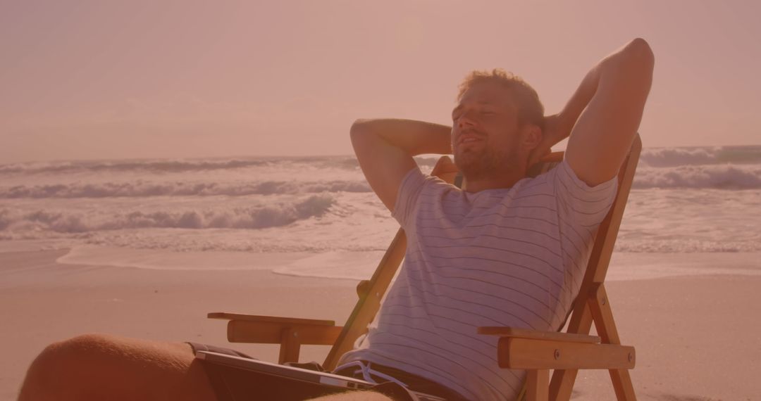 Man Relaxing on Beach during Sunset, Enjoying Leisure Time