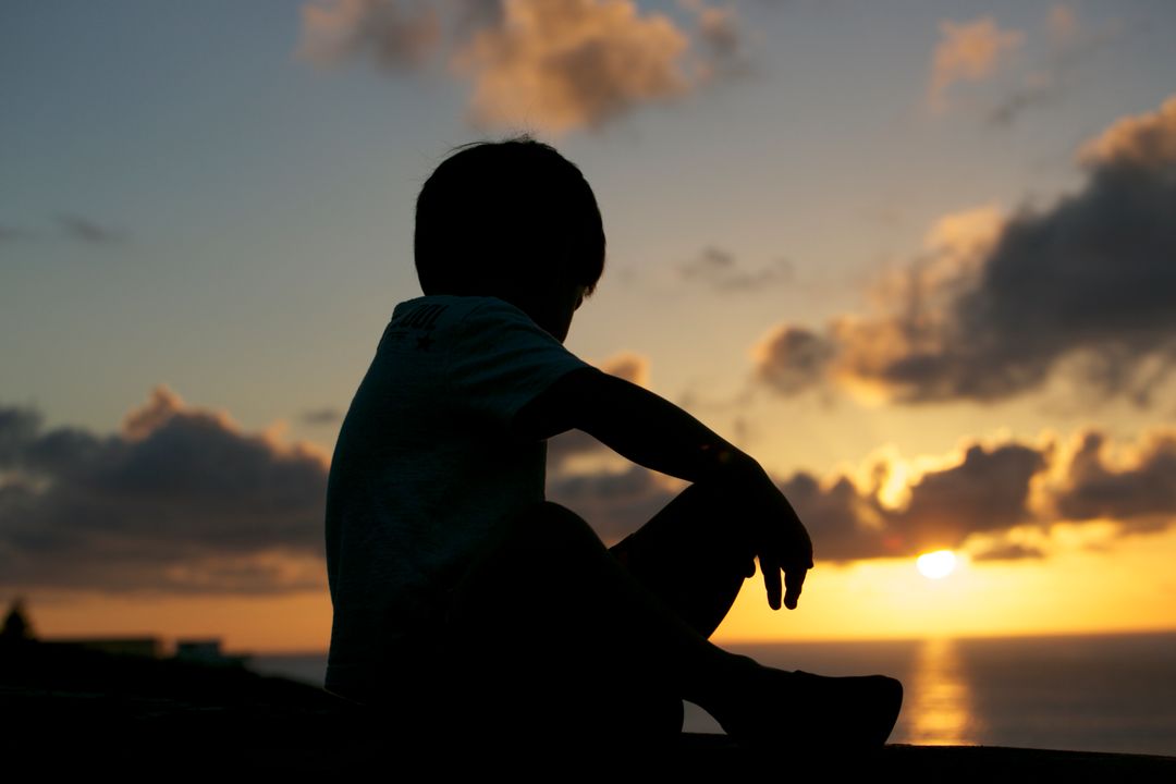 Child Silhouette Sitting on Beach at Sunset - Free Images, Stock Photos and Pictures on Pikwizard.com