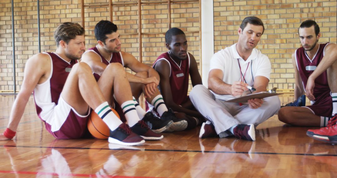 Basketball Coach Giving Strategy Talk to Diverse Team Players on Court - Free Images, Stock Photos and Pictures on Pikwizard.com