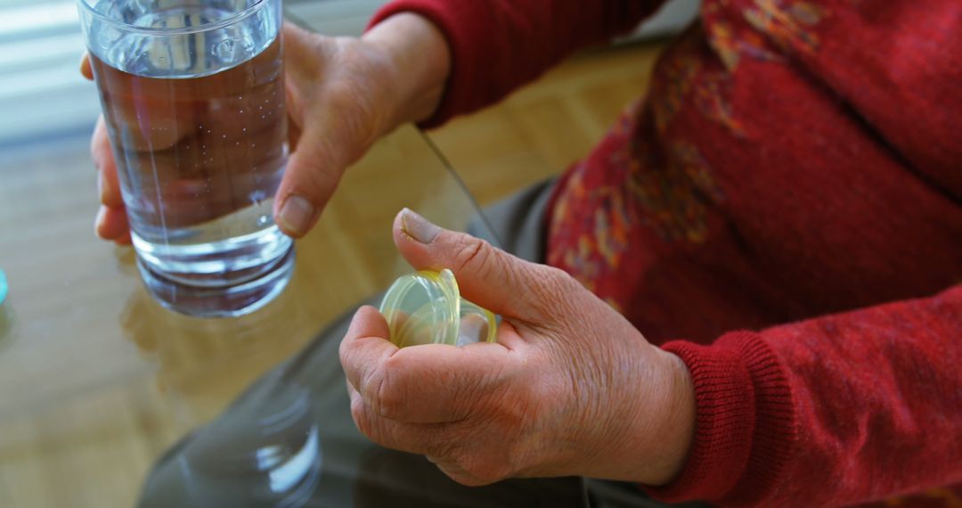 Elderly Person Holding Pill Bottle and Glass of Water - Free Images, Stock Photos and Pictures on Pikwizard.com